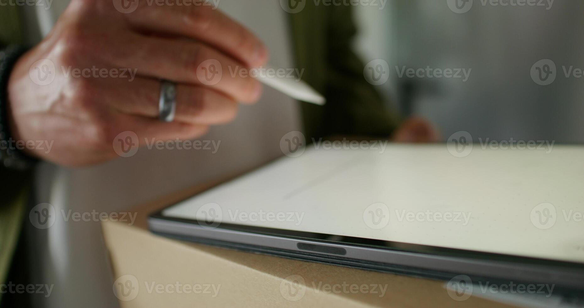 The man signs with a stylus on the tablet confirming receipt of the parcel. close-up of his hands, an unrecognizable person - person photo