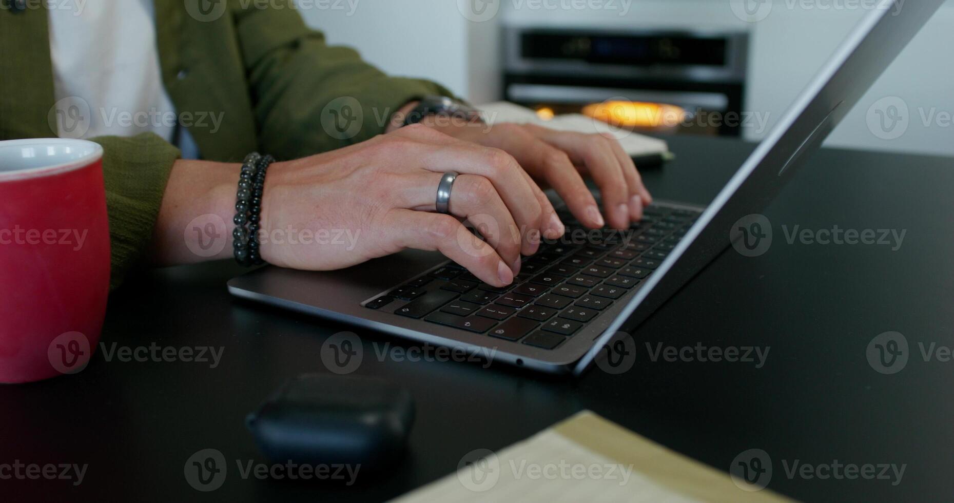 A man typing on a laptop keyboard sitting at his desk at home. Close-up of his hands, an unrecognizable person. Daylight - keyboard photo