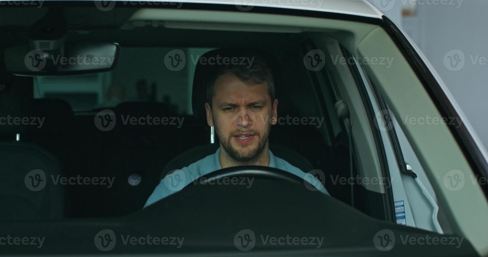 The customer sit in the driver's seat of the car. The car dealership manager is talking to him, standing nearby photo