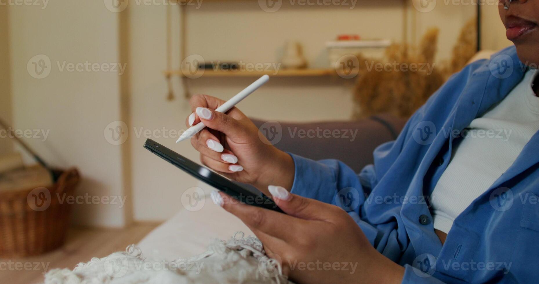 A woman in blue pajamas holding a cell phone and a cigarette photo