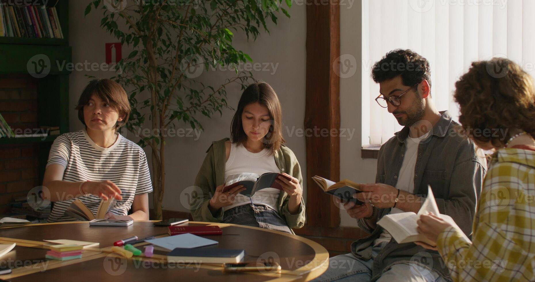 Men flip through the pages of their Bibles while sitting at a table indoors. The Bible Study Club. Daylight - sitting photo