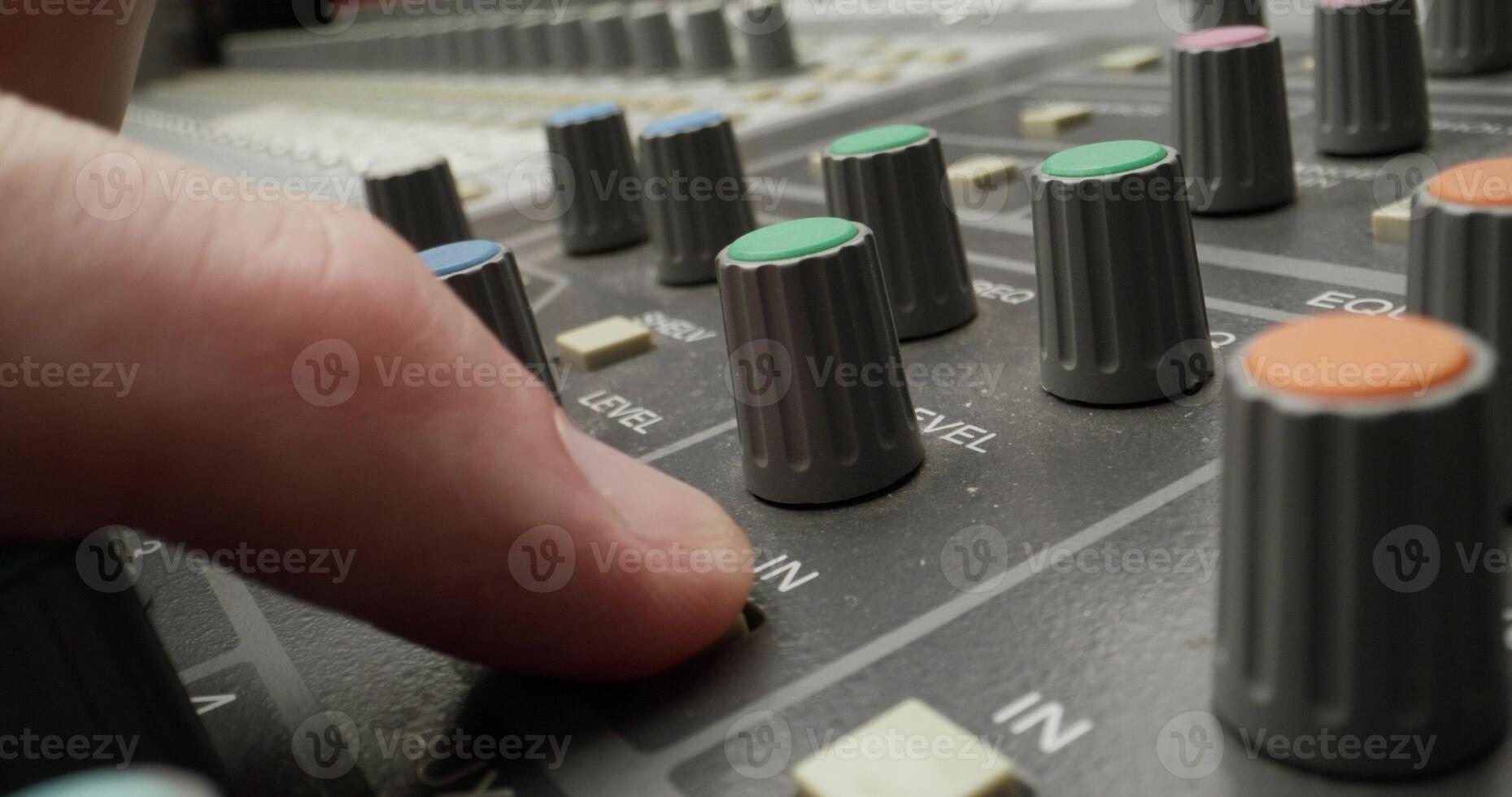 A man controls a mixing console while recording audio in the studio. Close-up of his hand, an unrecognizable person photo