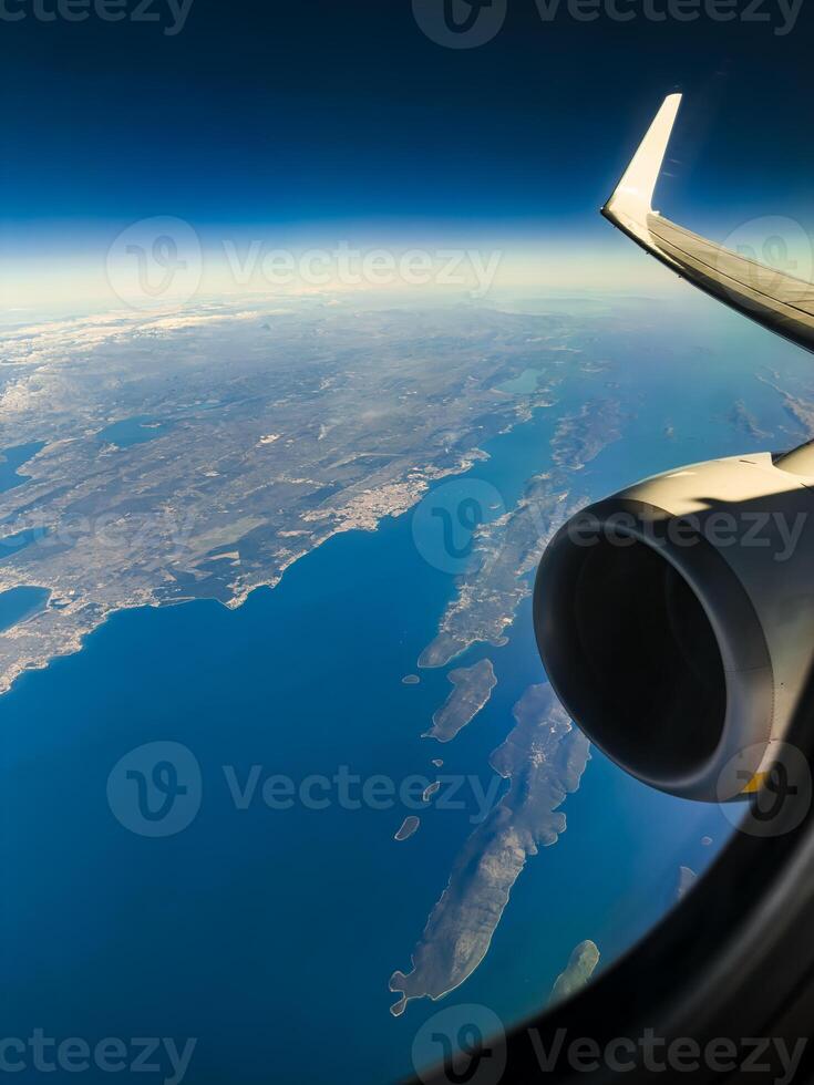 View From The Window Of A Flying Plane Over The Ocean photo