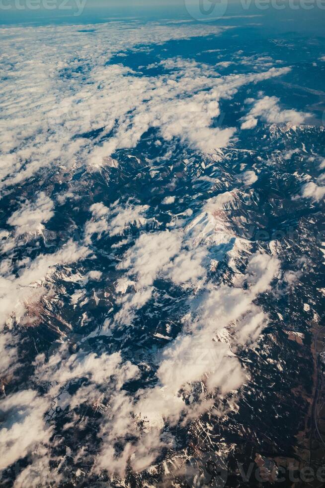 Clouds And Snow Over The Mountains From Above photo