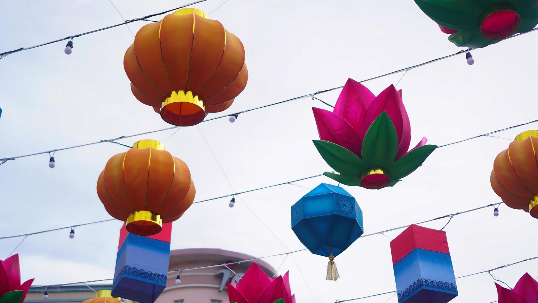 a bunch of colorful paper lanterns hanging from a string photo