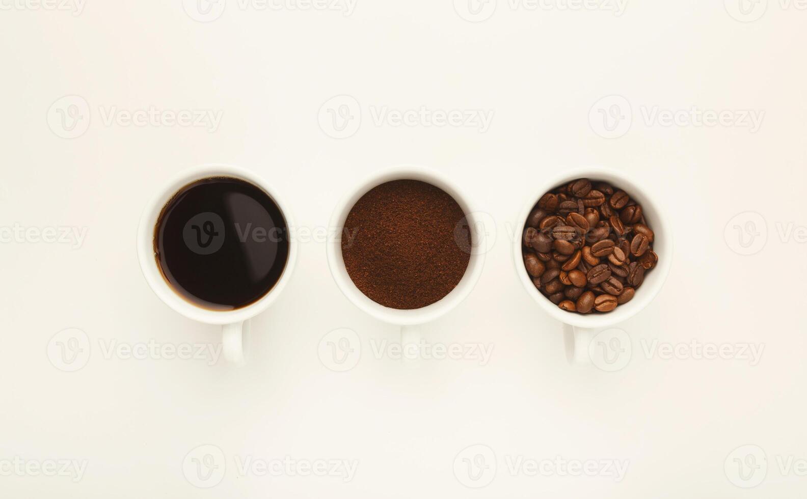 Assortment of coffee in cups. Whole beans, ground coffee and freshly brewed americano isolated on white background, top view, copy space photo