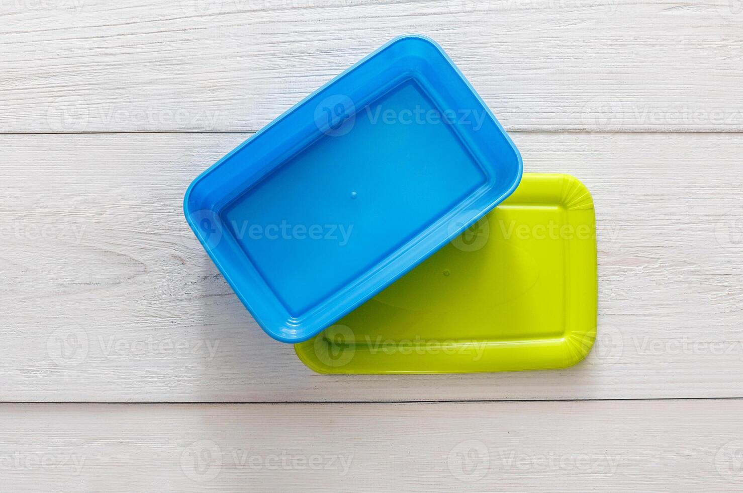 Empty plastic lunch boxes on white wood, top view. Green and blue containers photo