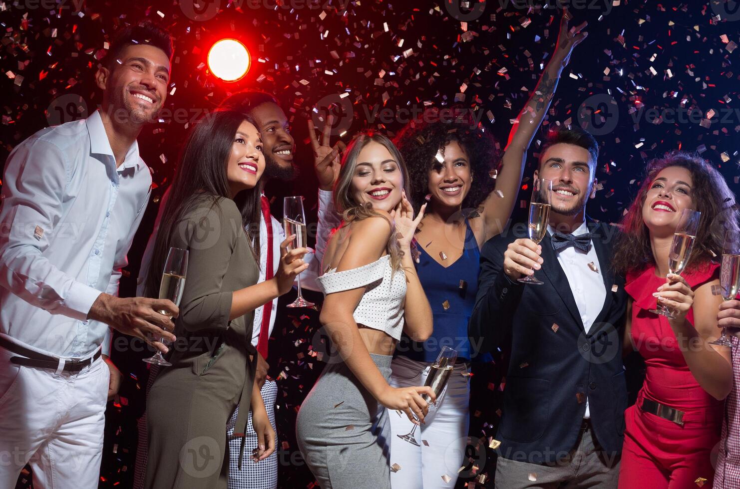 Night club reportage. Group of happy people smiling upwards at New Year party photo