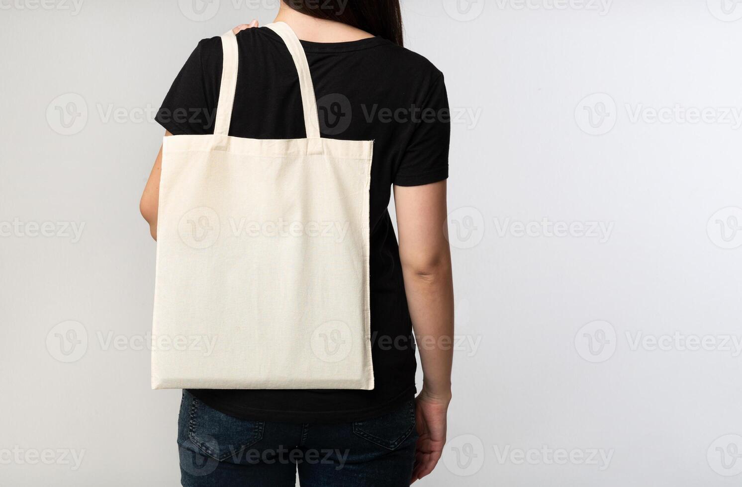 Say No To Plastic. Unrecognizable Brunette Girl Holding Eco Bag On White Studio Background. Back View, Cropped, Free Space photo
