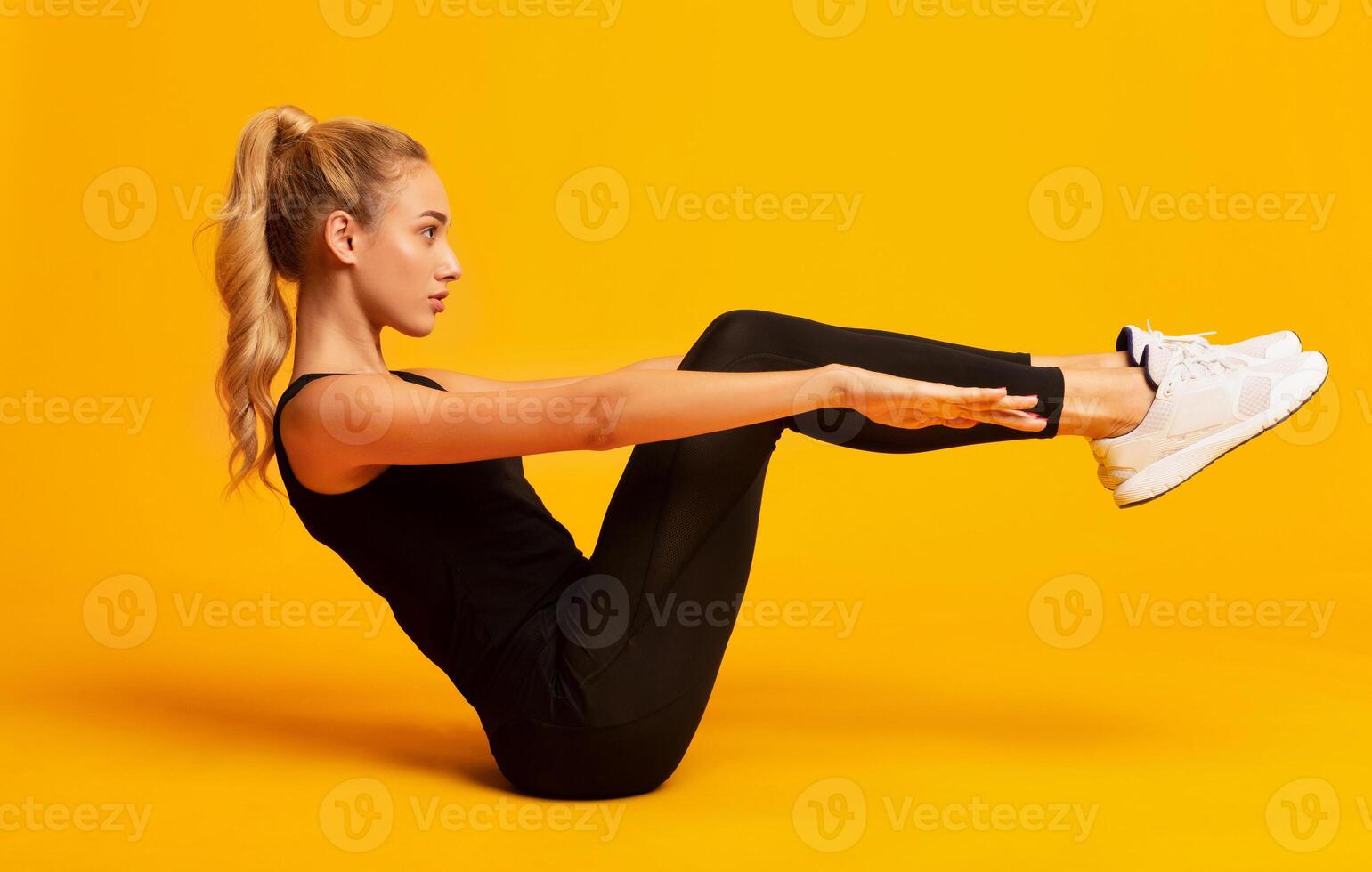 Body Shaping Workout. Girl Doing Abs Exercise With Leg Raise On Yellow Studio Background. photo