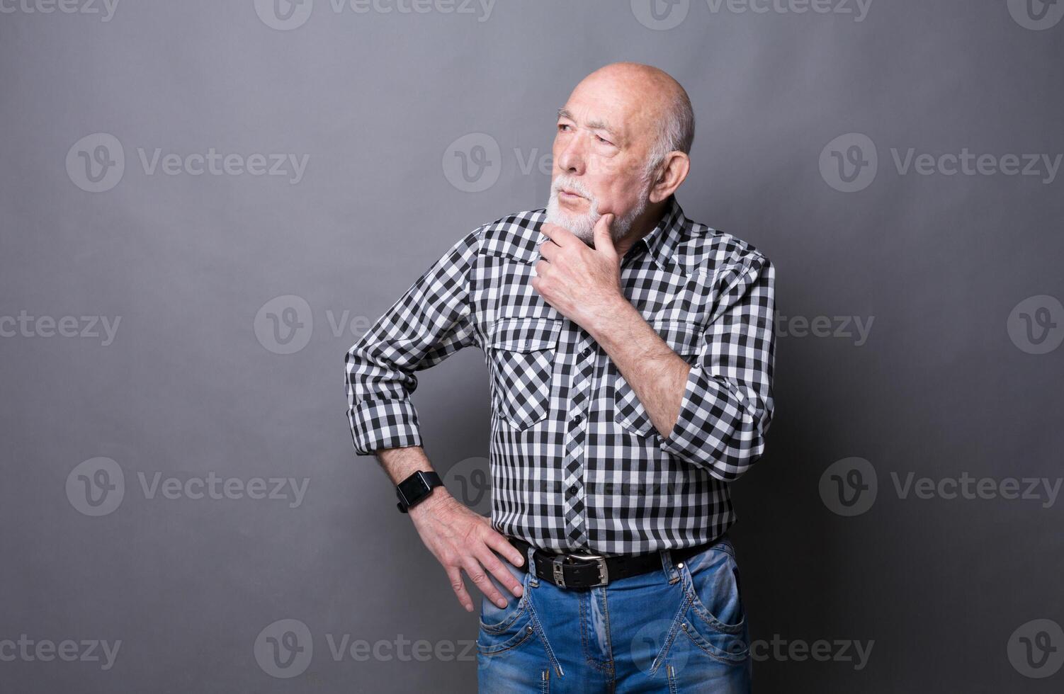 Pensive mature man looking away, copy space. Senior male dreaming about something, lost in thoughts, gray studio background photo