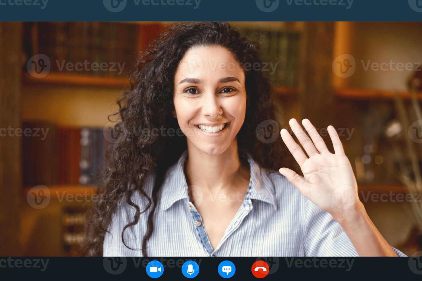 Head shot of smiling young female employee worker waving hand to webcam, greeting colleagues at remote brainstorm online meeting, woman using computer call software app, laptop screen view photo