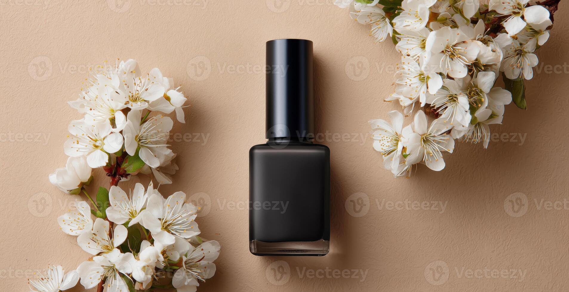 A polished black gel nail polish bottle is surrounded by delicate white blossoms on a neutral surface. The elegant arrangement highlights the beauty of nail care in a refined setting. photo