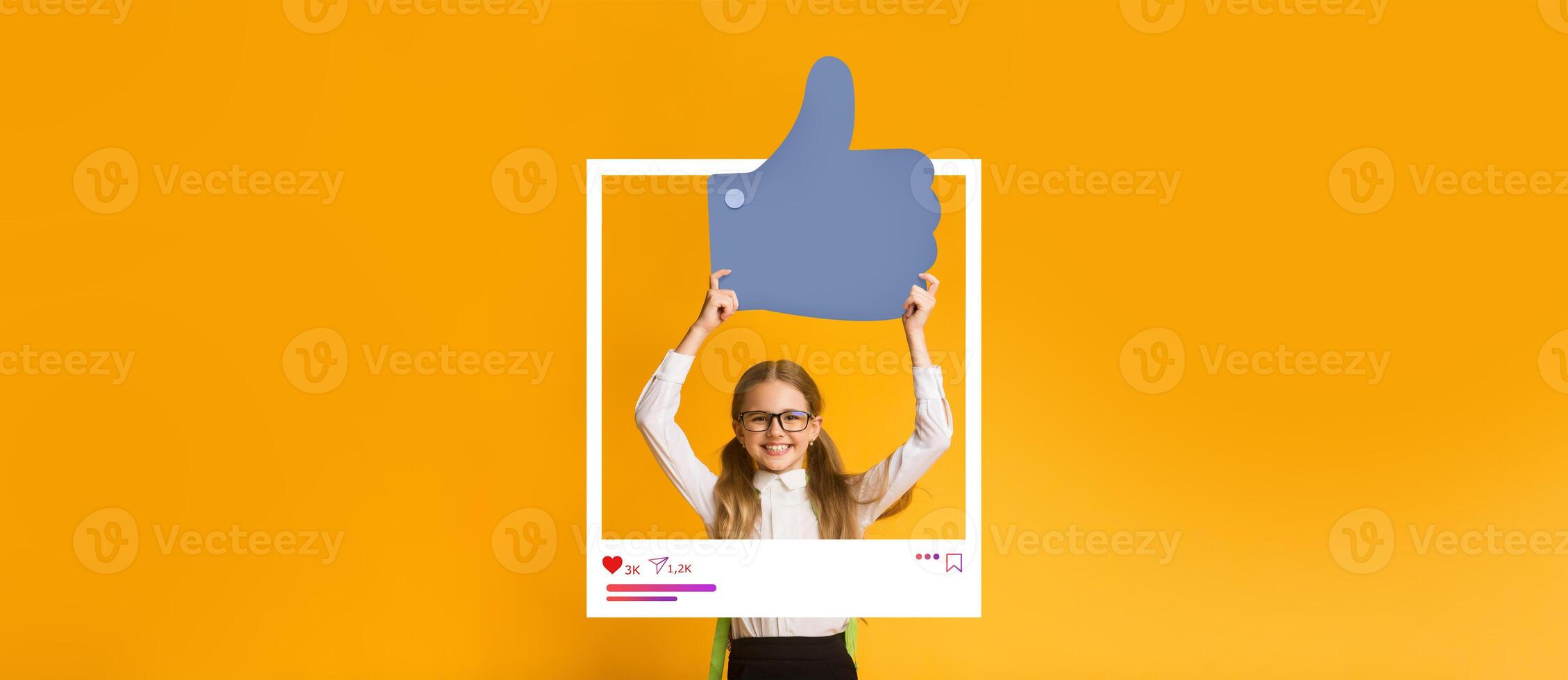 A young content creator stands with a large thumbs up symbol, expressing positivity about online engagement. The bright yellow backdrop highlights an energetic vibe, ideal for social media. photo