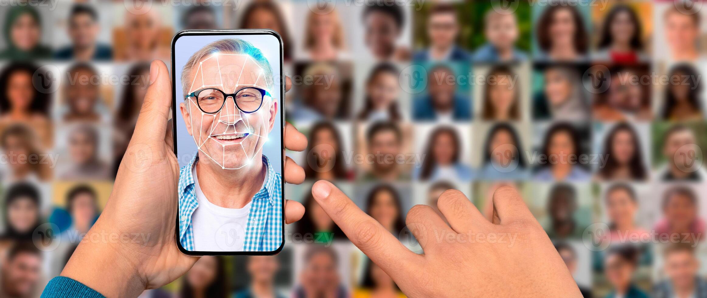 A person uses a smartphone to scan their face for identification purposes. The screen displays a facial recognition overlay, while various portraits are blurred in the background. photo