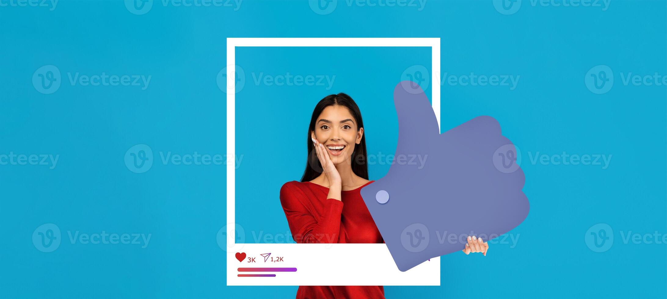 A young person expresses joy with a surprised expression while holding a large thumbs up symbol. The bright blue backdrop enhances the energetic vibe of this social media engagement moment. photo