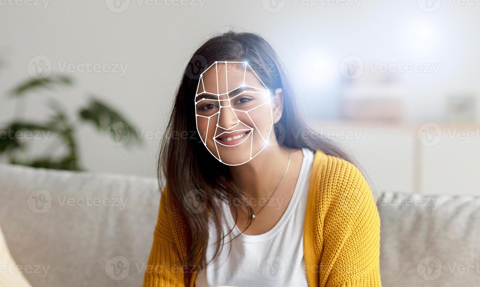 Indian woman sits on a couch with a smiling expression as facial recognition technology analyzes her features in a home setting. This reflects a shift towards digital identification in daily activities. photo