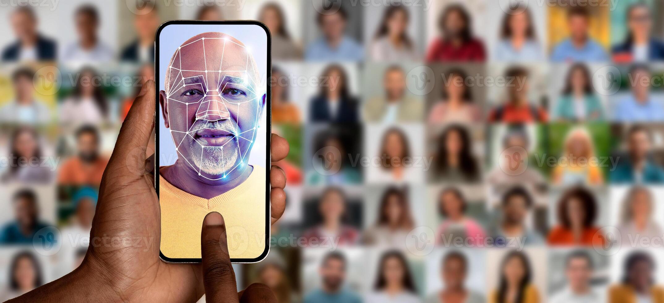 A person scans their face with a smartphone while surrounded by a collage of portraits. This modern technology highlights face identification, showcasing its capabilities in a connected world. photo