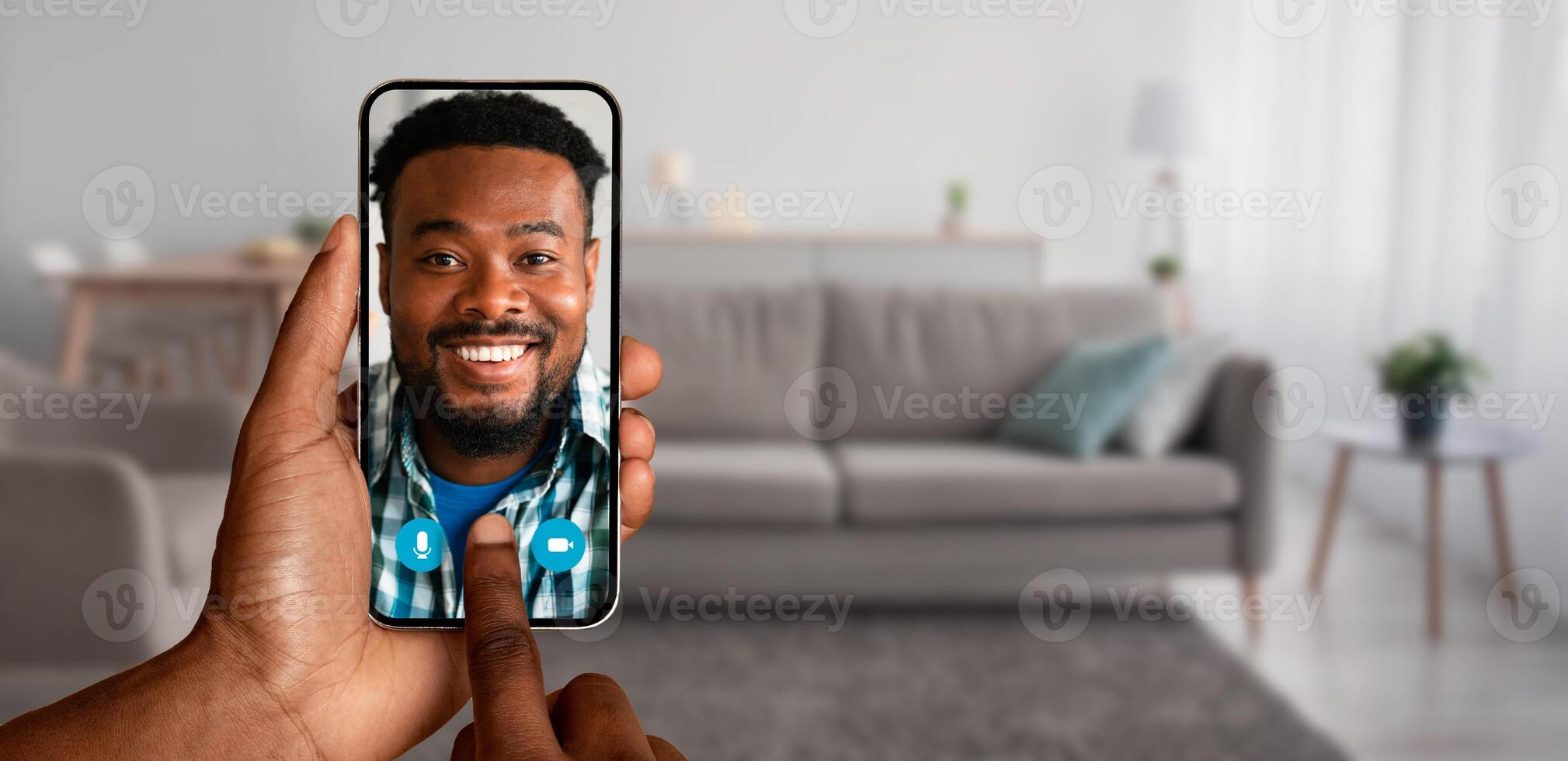 A person is enjoying a call from their home, connect with smiling man on the screen of their smartphone, showcasing the ease of modern communication. photo
