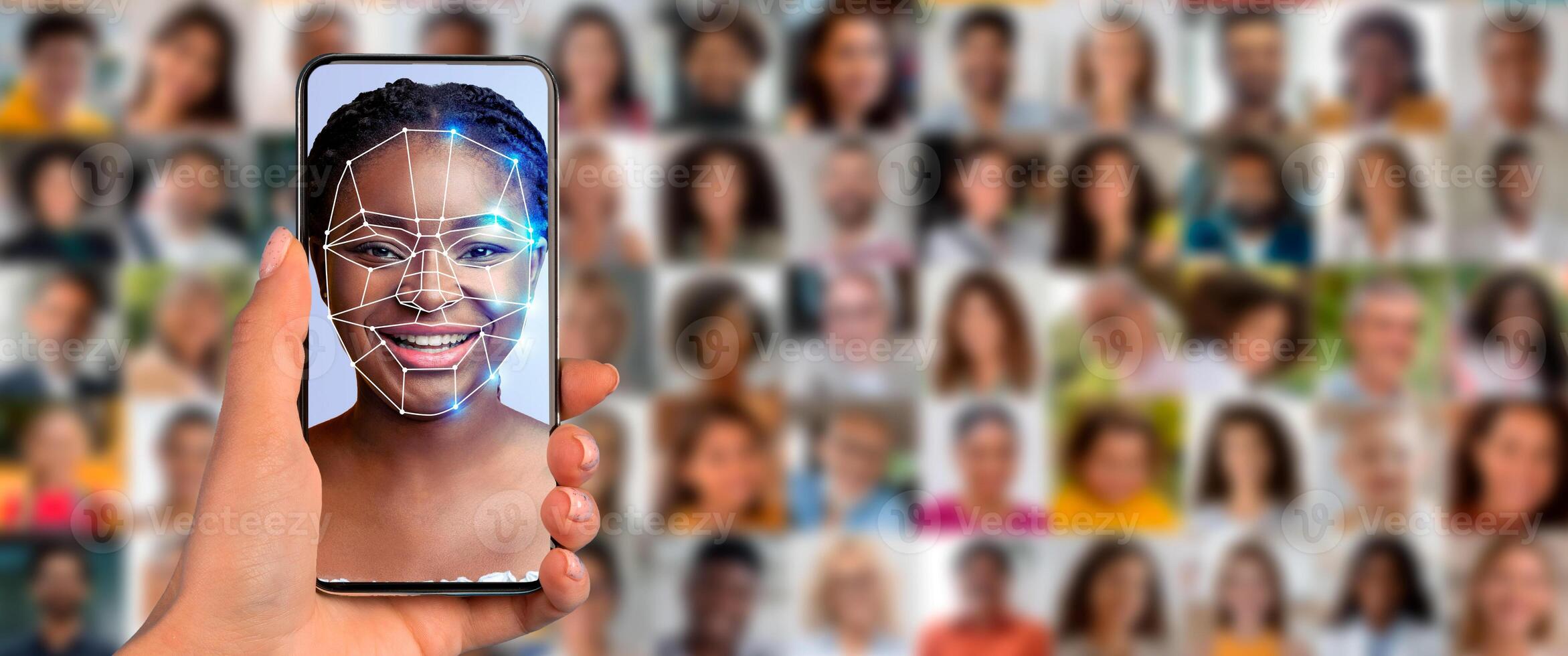 A person holds a smartphone displaying a face scan while surrounded by a collage of diverse portraits. This showcases the advancement of identification technology in daily life. photo