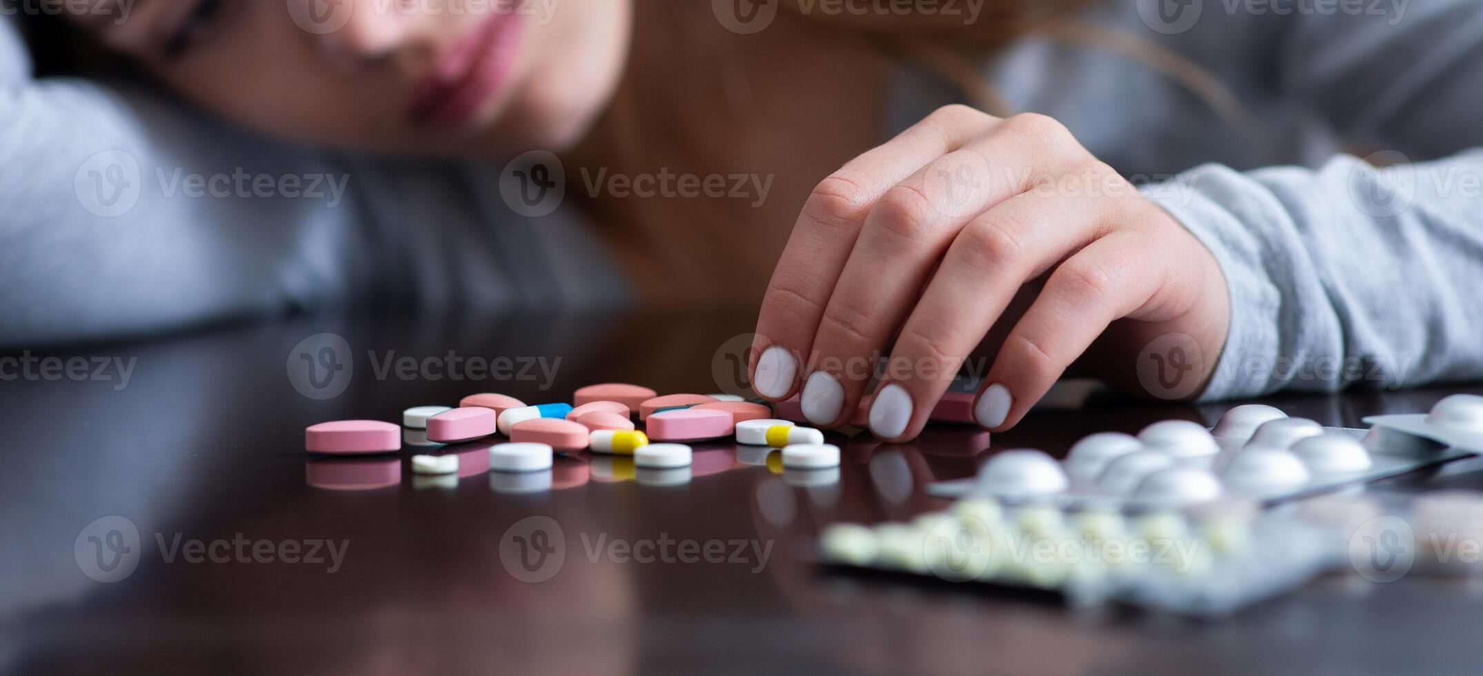 Emotional exhaustion and suicide. Cropped view of depressed young lady with pills planning to kill herself, banner design. Millennial woman suffering from depression, overdosing on antidepressants photo