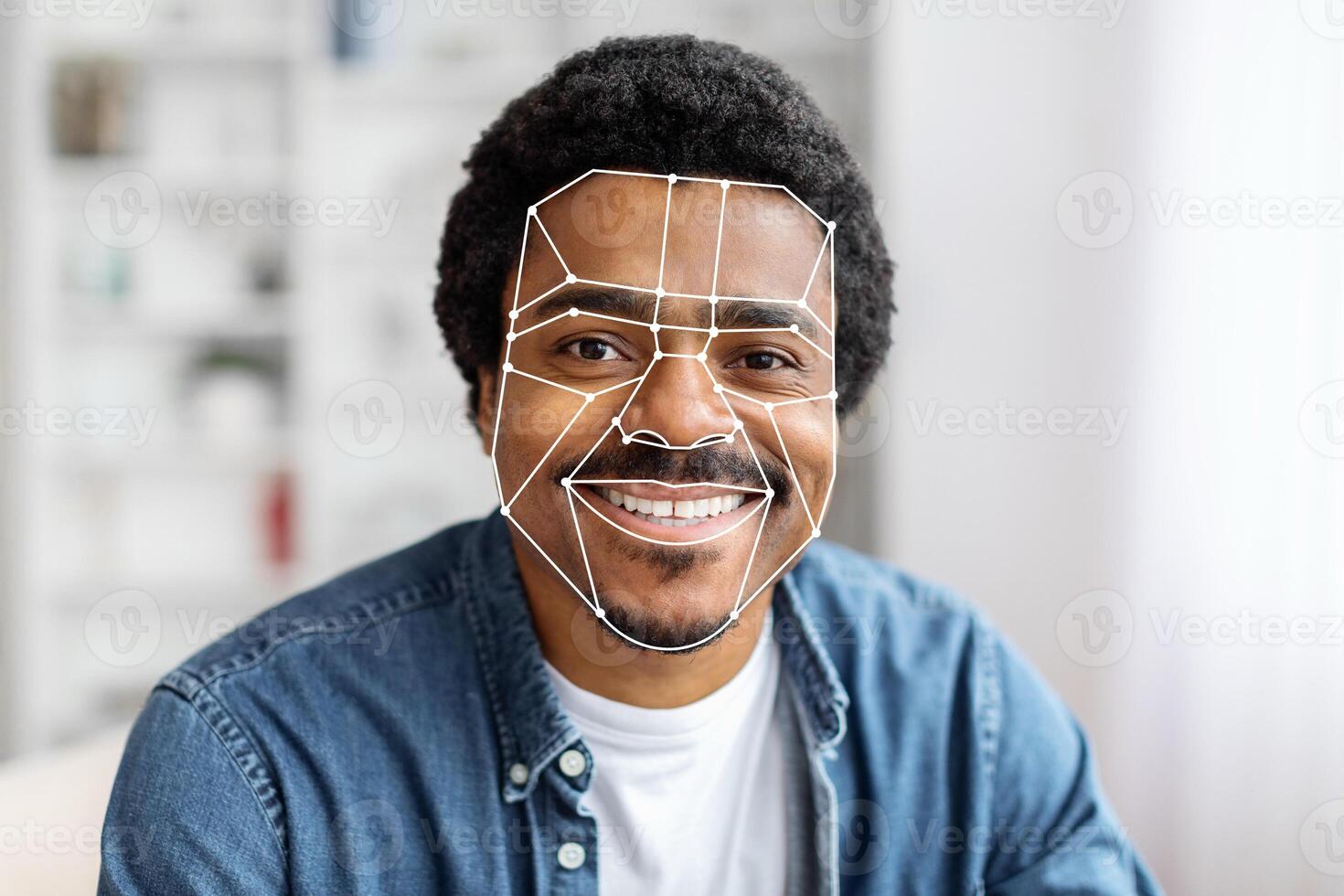 African American man is using facial recognition technology for identification at home. The digital overlay emphasizes facial features, showcasing advanced tech for seamless verification. photo