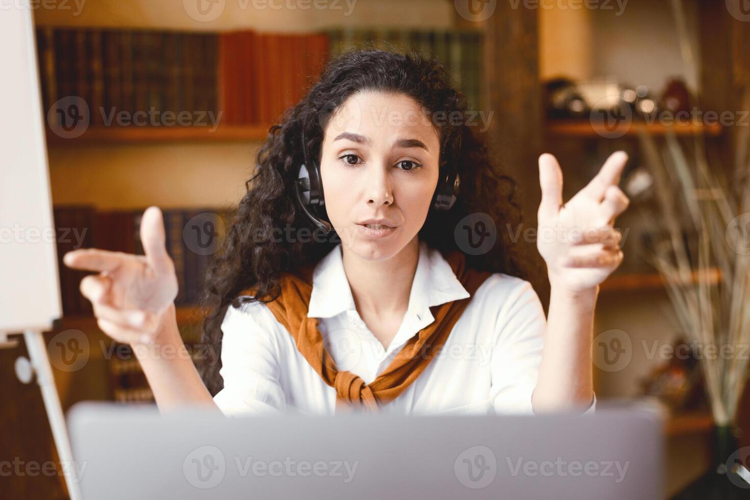 Remote Work. Portrait of focused woman sitting at desk, having call on laptop, explaining lesson to students or working and talking to colleagues and gesturing to webcam, consulting client photo