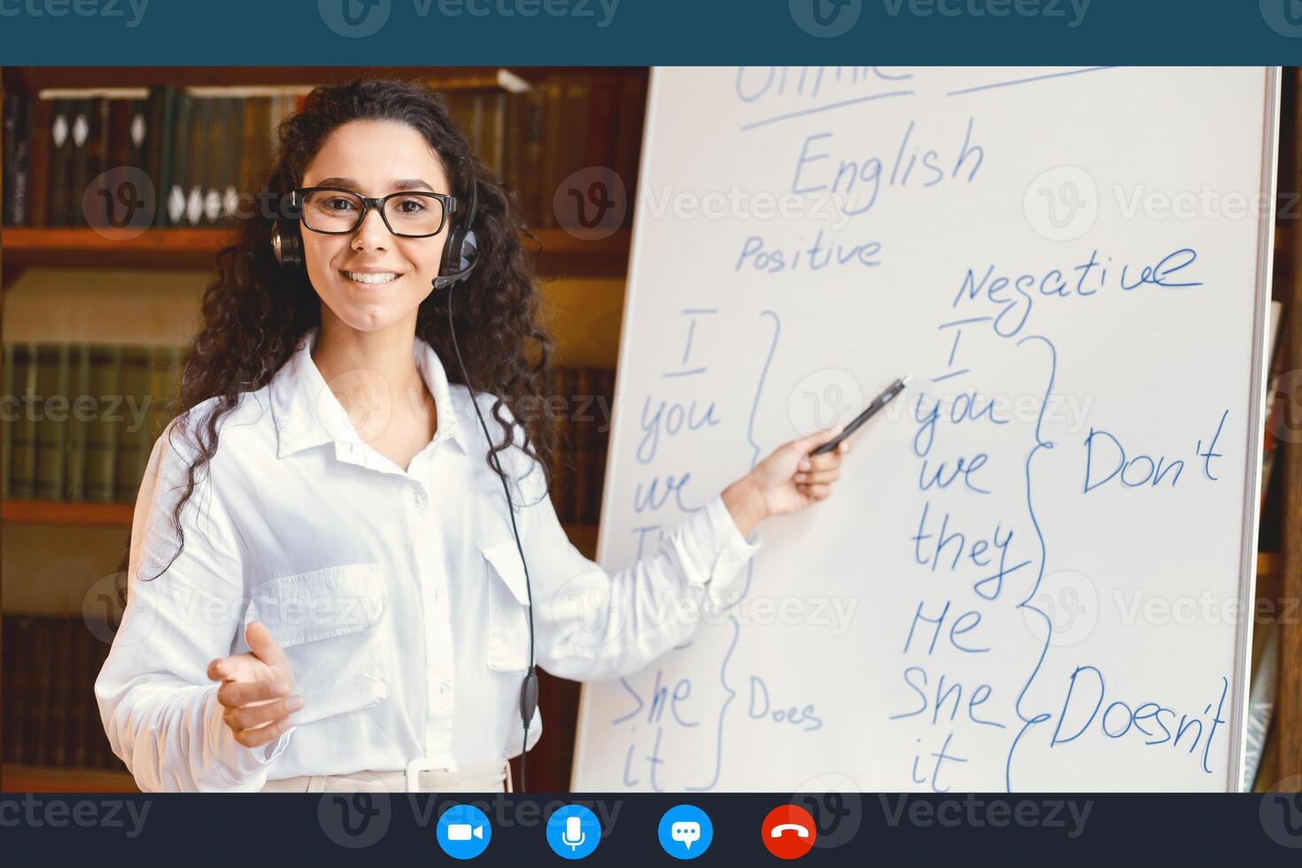 Distance Education And Technology. Woman In Glasses And Headset Having Conference, Teaching Foreign Languages, Talking To Camera During Web Call, Pointing At Whiteboard With Grammar Rules photo