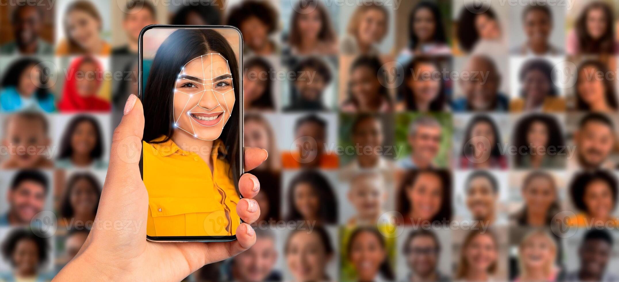 A person holds a smartphone displaying a facial recognition scan of their face. The background features a collage of diverse faces, showcasing the technology's application in identification. photo