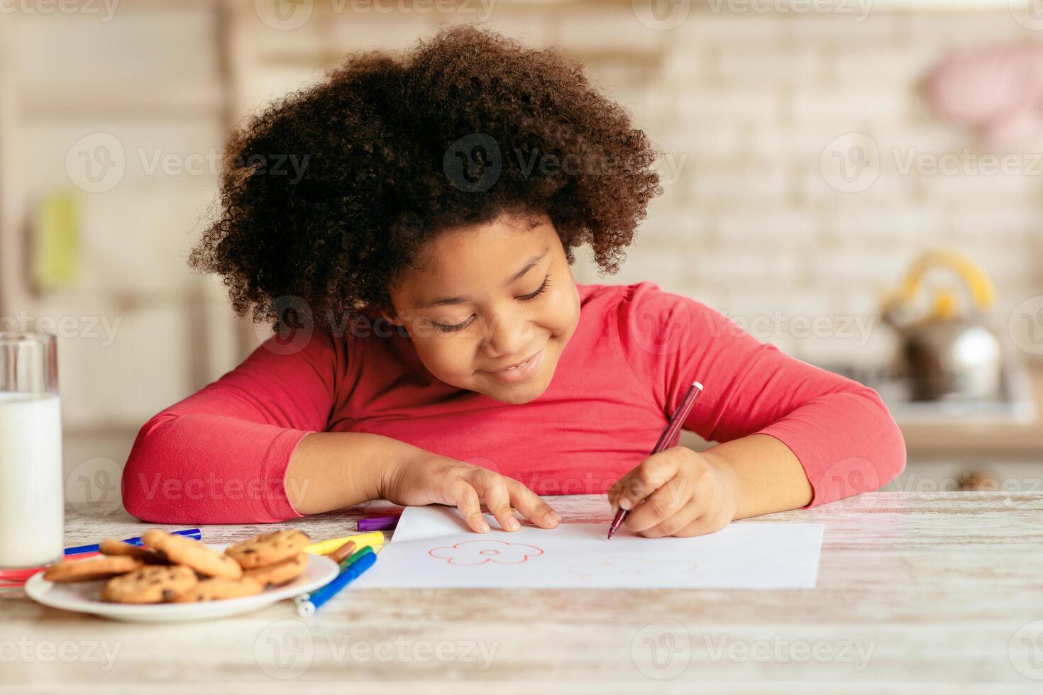 Portrait Of Adorable Little African American Girl Drawing In Kitchen, Pretty Black Female Kid Sitting At Table With Cookies And Milk, Enjoying Relaxing At Home, Closeup Shot With Free Space photo