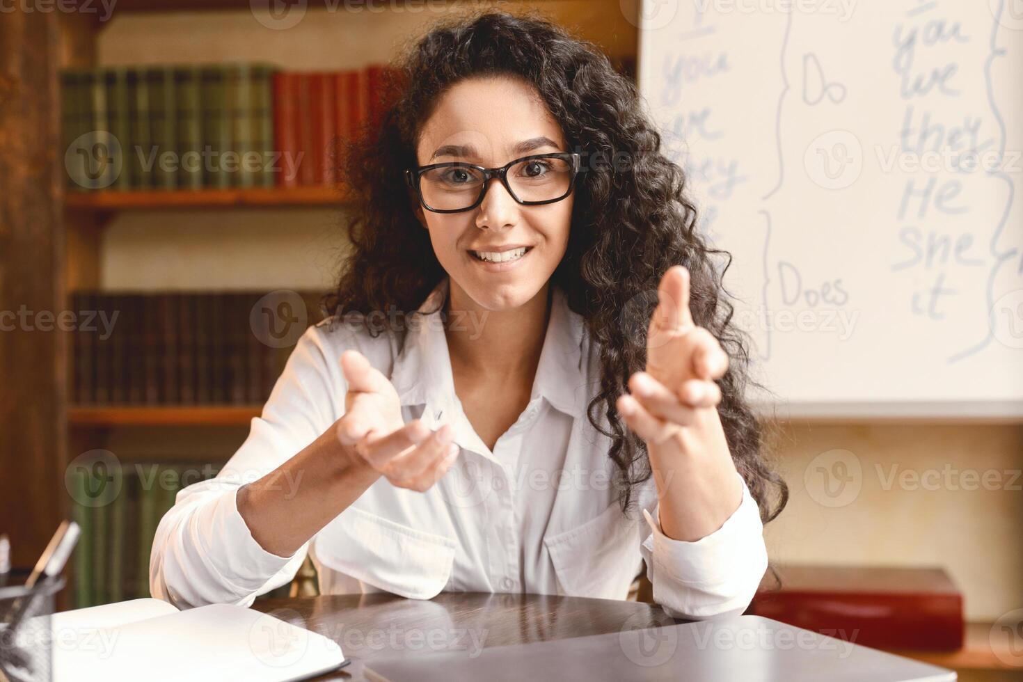Remote Distant Communication Concept. Woman In Eyeglasses Having Conference, Teaching Foreign Languages, Talking And Gesturing At Camera During Online Call, Sitting At Desk In Home Office photo