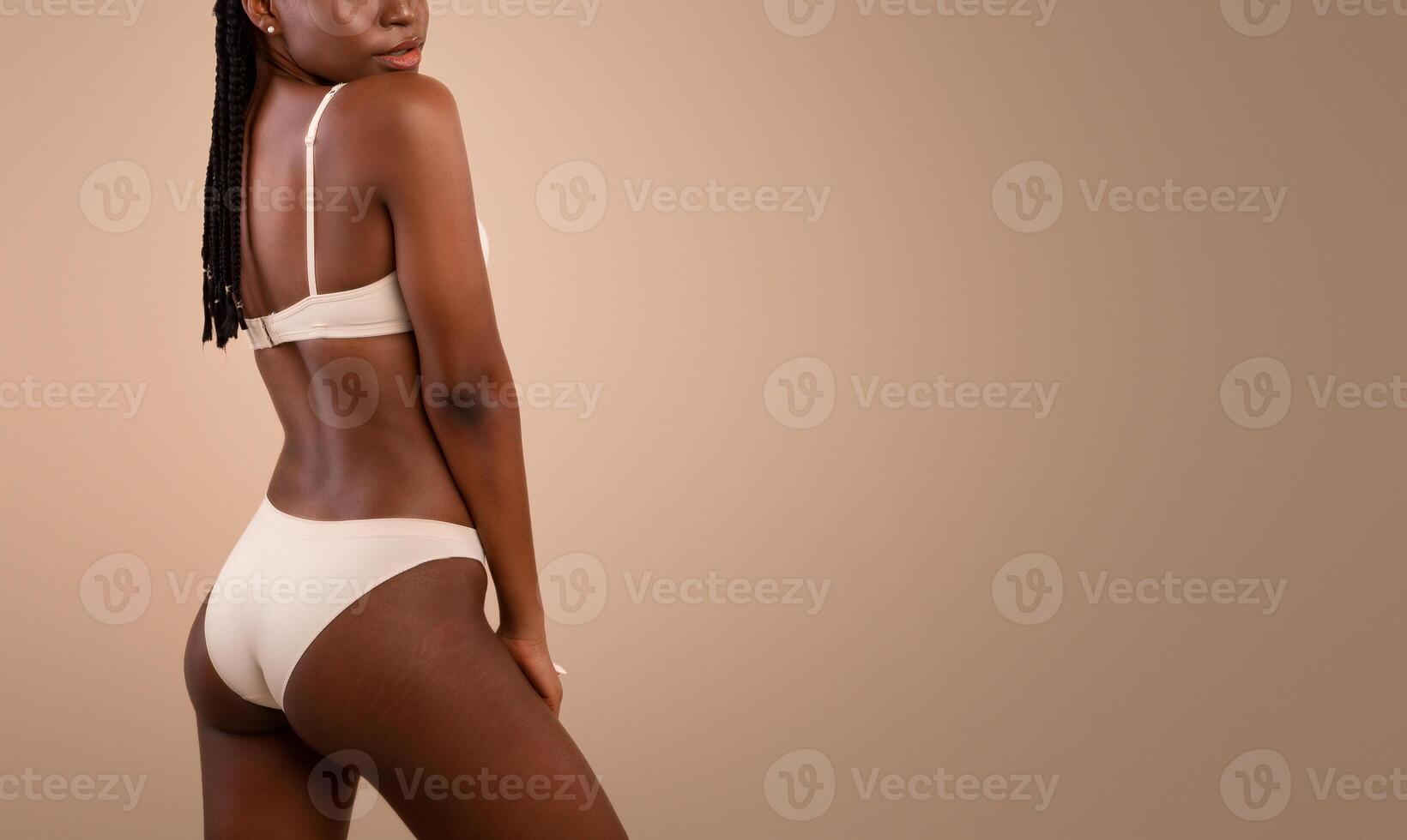Cropped Portrait Of Young Slim Black Woman In Underwear With Body Stretch Marks Signs Posing Over Beige Studio Background, Positive African Lady Enjoying Her Natural Beauty And Skin Imperfections photo