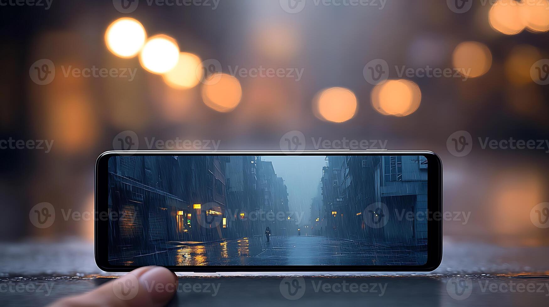 A hand holding a smartphone displaying a rainy street scene with a solitary figure in the background photo