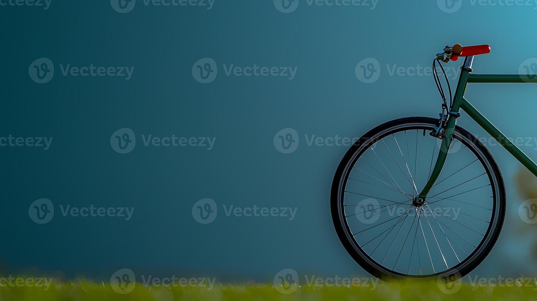 A minimalist bicycle resting against a smooth blue wall, surrounded by lush green grass photo