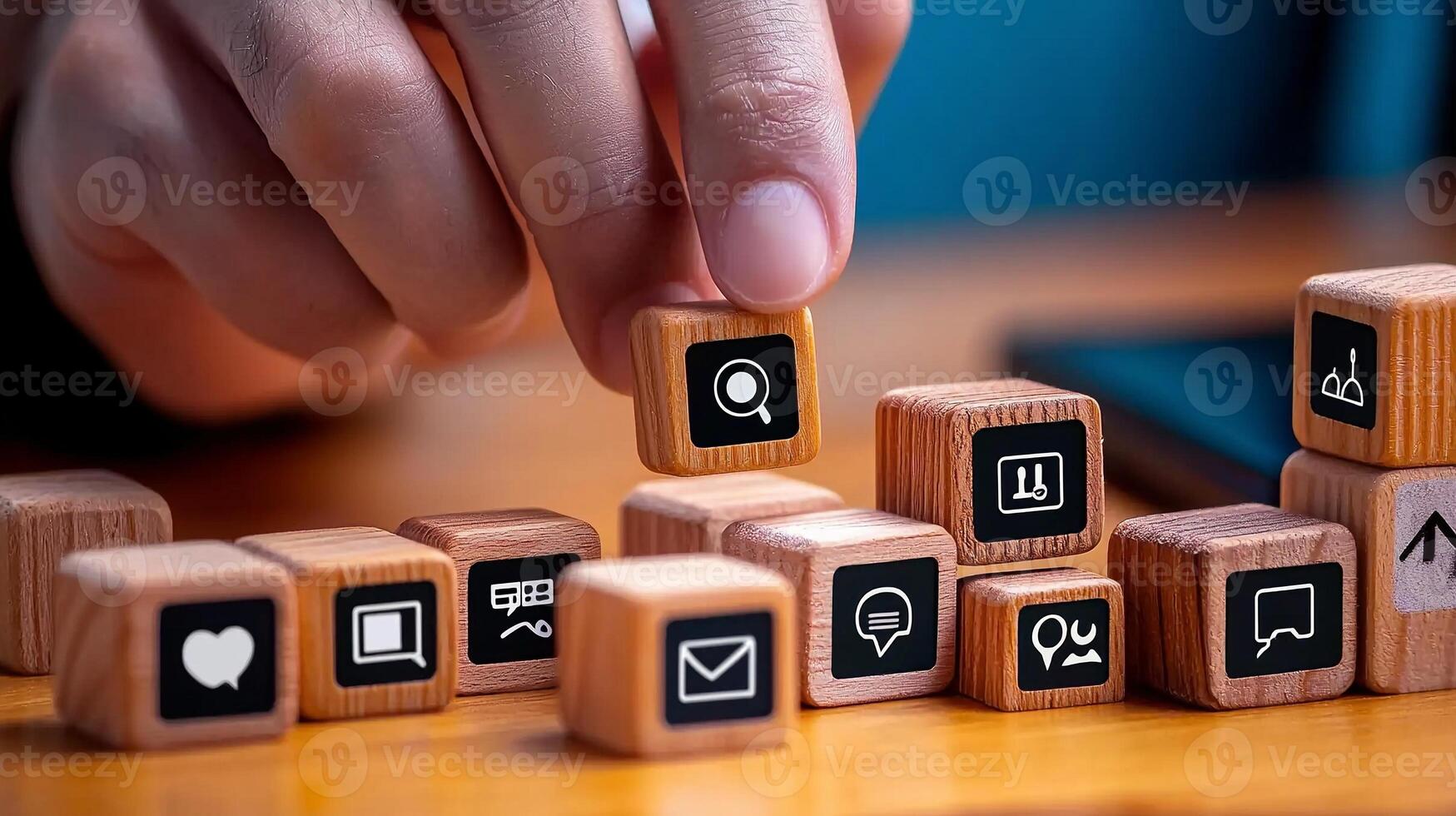 A person arranging wooden blocks with various icons, symbolizing communication and technology photo
