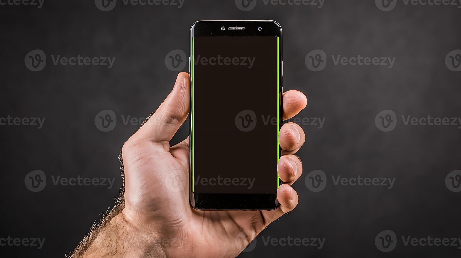 A person holding a smartphone with a blank screen against a dark textured background photo