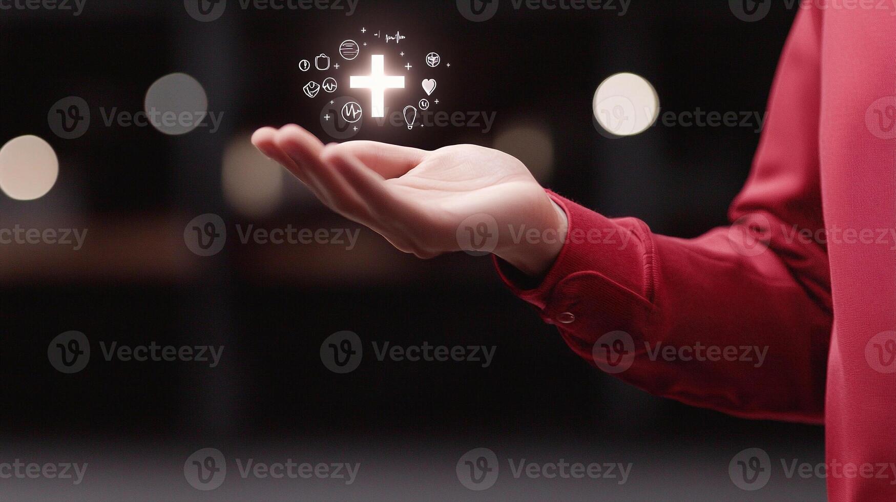A person in a red shirt holds an open hand displaying glowing symbols representing health and wellness photo