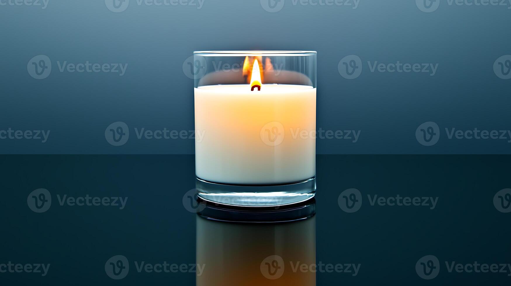 A serene candle burns softly in a glass holder against a gradient blue background photo