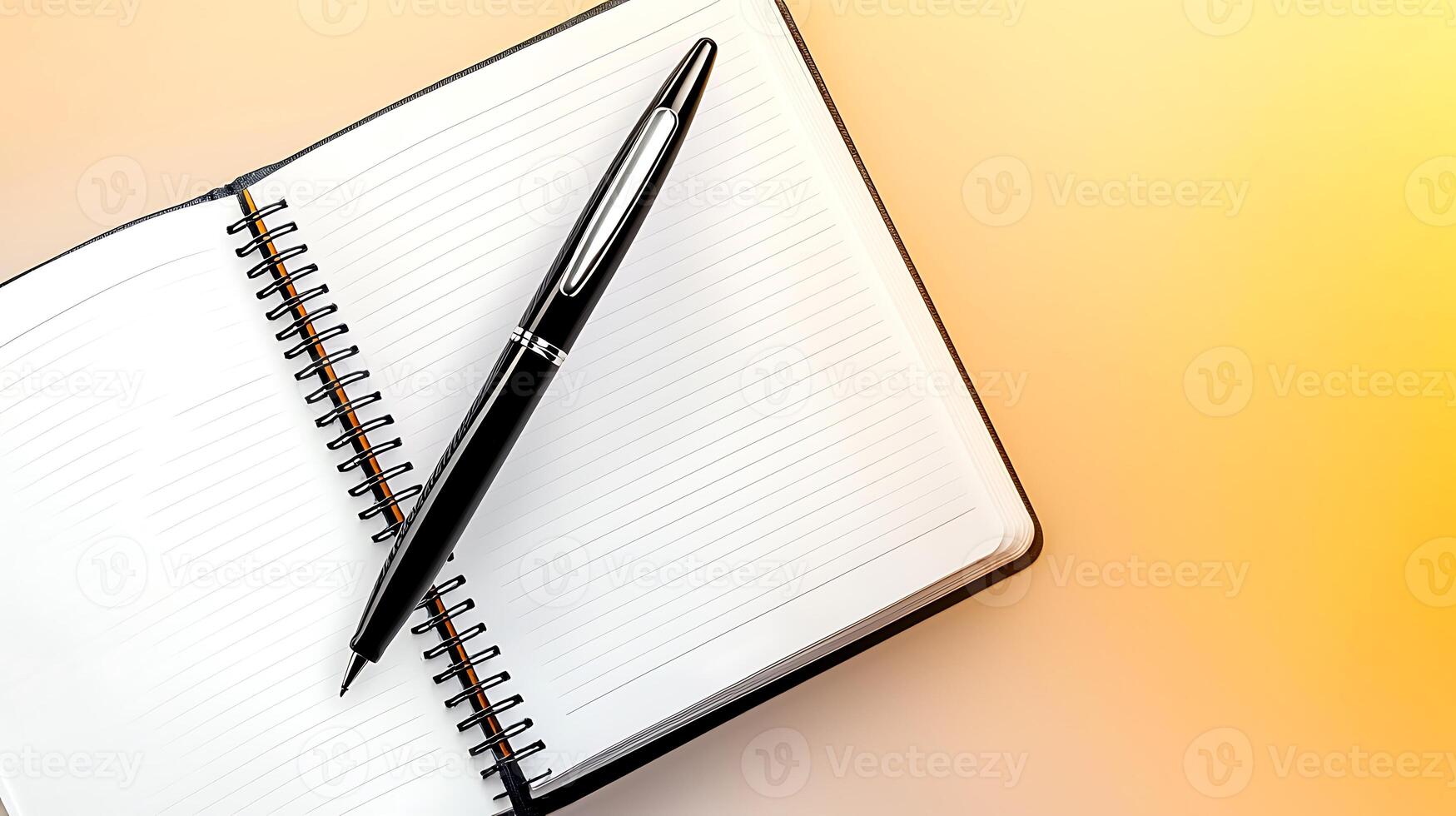 A sleek black pen resting on an open blank notebook with a warm gradient background photo
