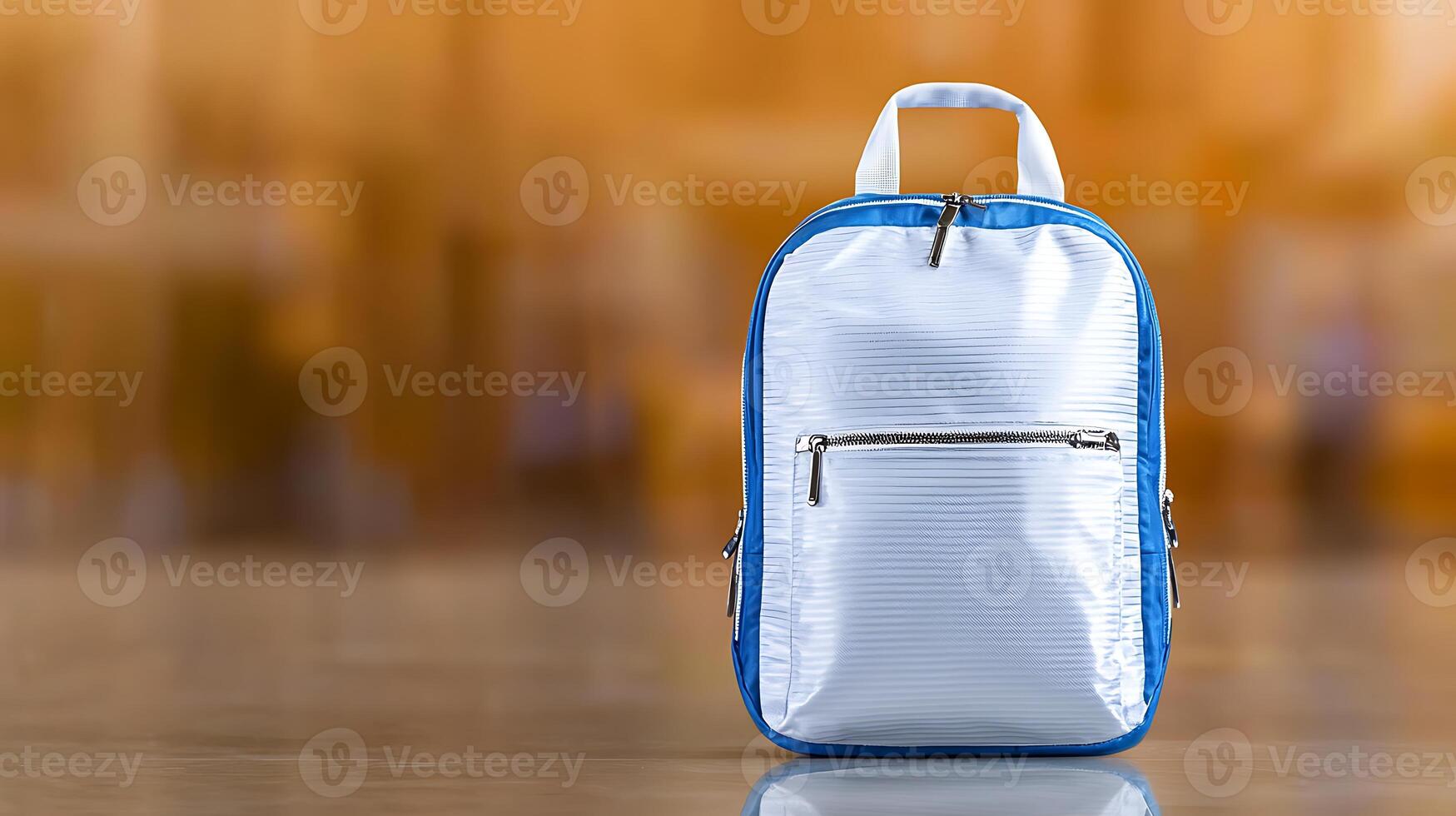 A sleek blue and white backpack stands alone on a polished floor in a spacious, blurred retail space photo