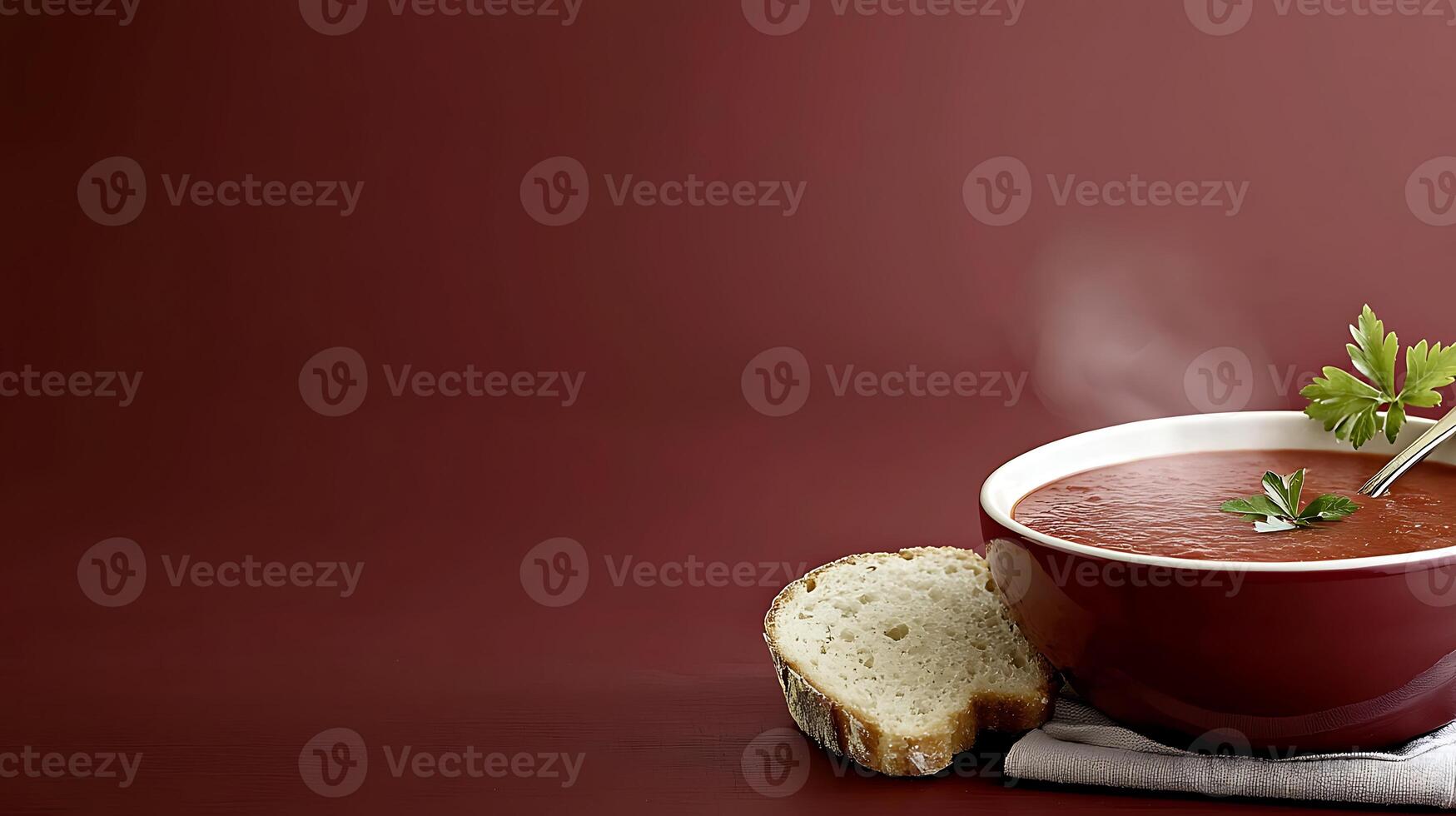A steaming bowl of tomato soup garnished with parsley, accompanied by a slice of bread photo