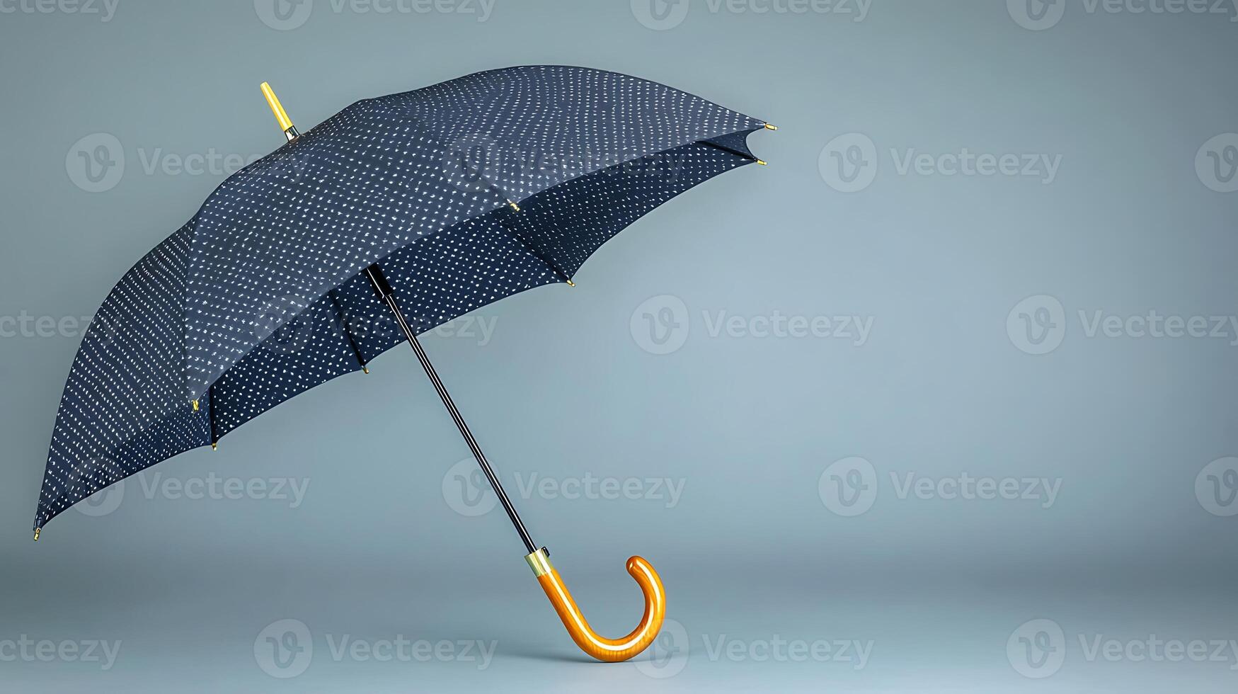 A stylish umbrella with a patterned canopy stands elegantly against a minimalist gray backdrop photo