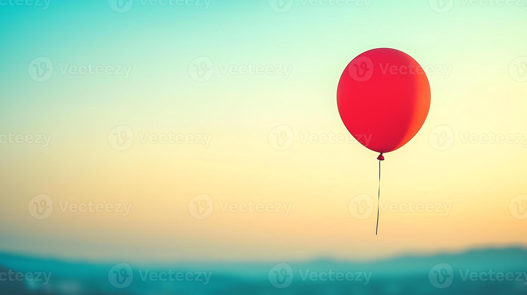 A vibrant red balloon floating against a soft sunset sky, evoking feelings of joy and nostalgia photo