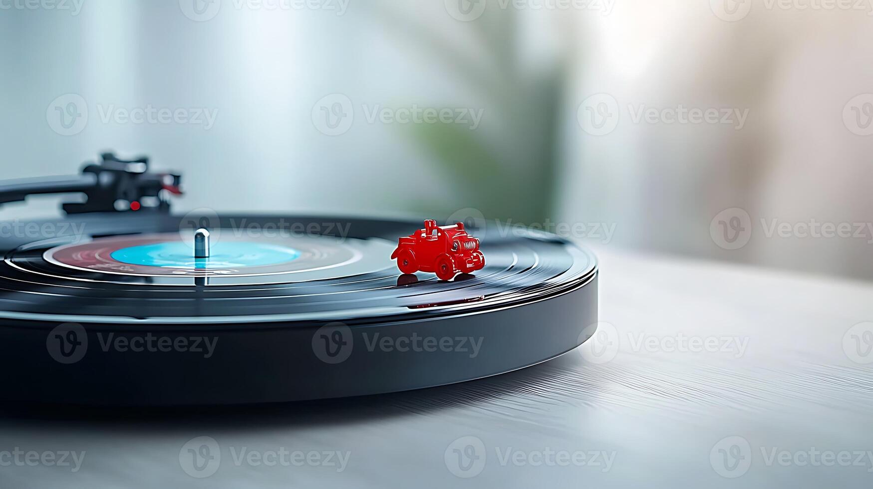 A vibrant red gummy bear sits atop a spinning vinyl record on a wooden table, with soft background light photo