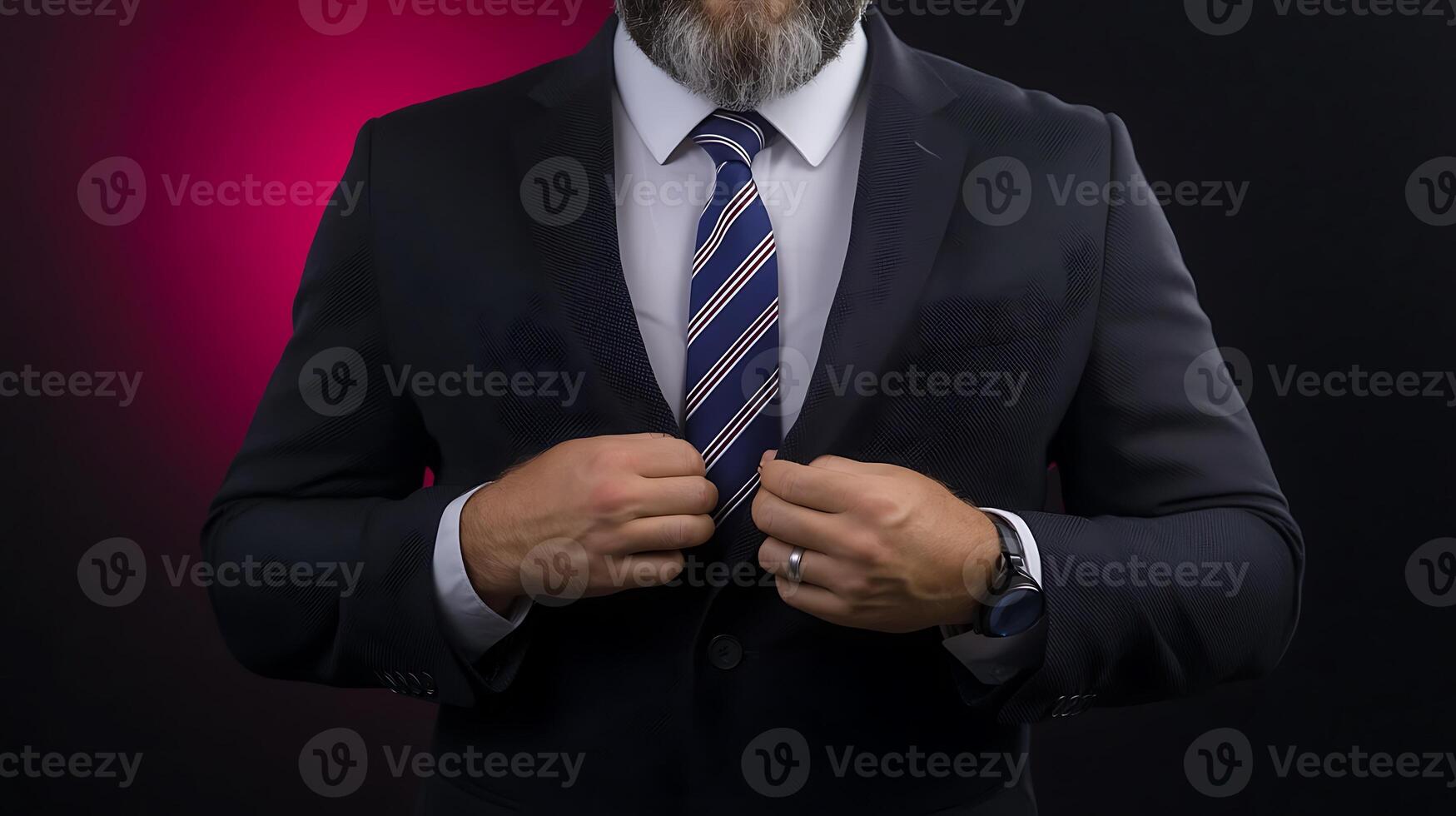 A well-dressed man adjusting his suit jacket against a vibrant pink and black background photo