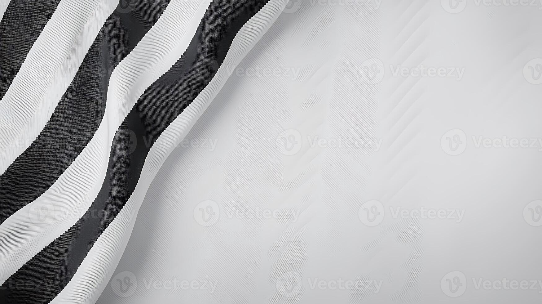 Abstract black and white striped fabric drapes softly against a light background, creating depth photo