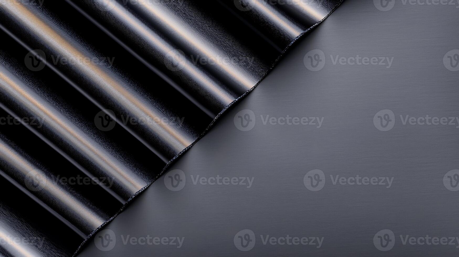 Abstract close-up of black metallic folds against a smooth dark surface, creating a sleek design photo