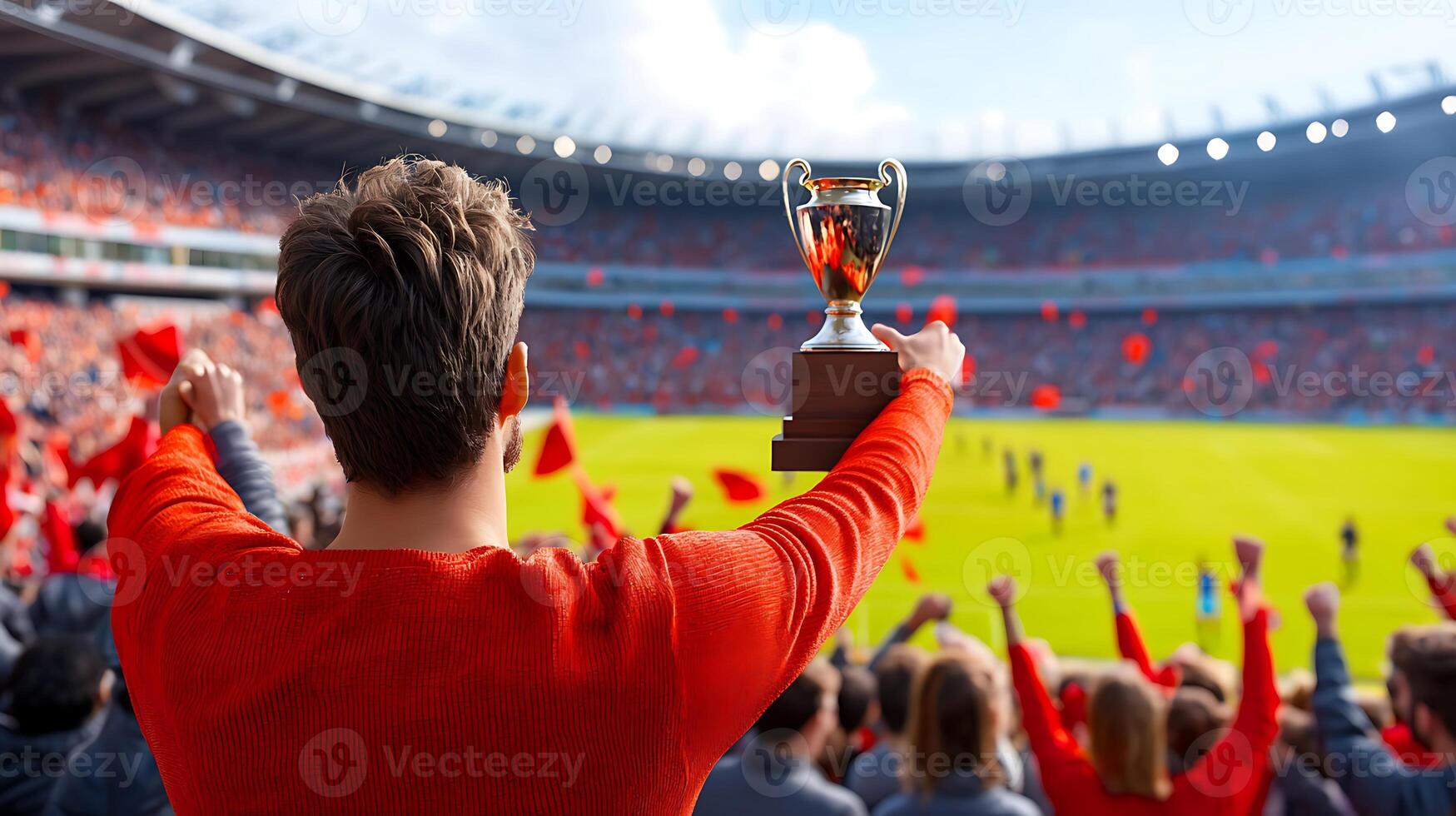 Celebrating victory with a trophy in a packed stadium, fans cheering with red flags in the background photo