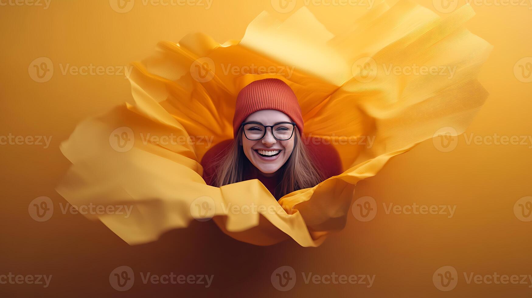 Cheerful woman in a vibrant yellow backdrop, smiling amidst flowing fabric, evoking joy photo