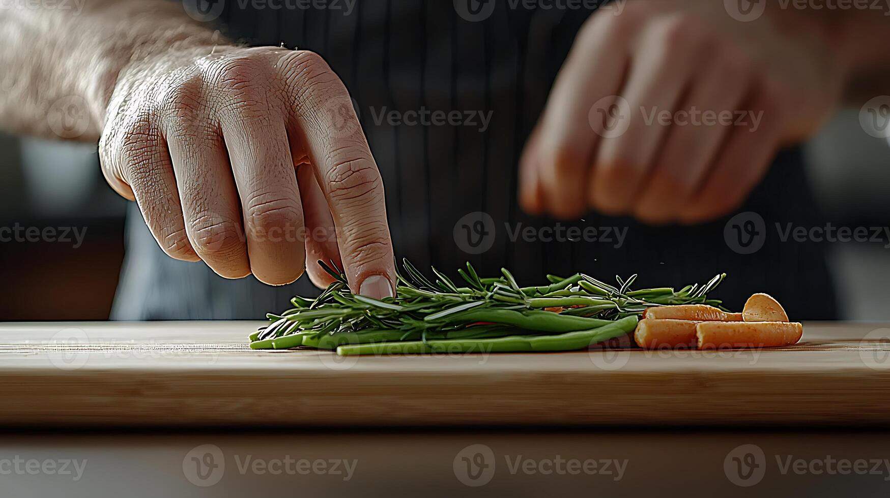 Chef carefully arranging fresh herbs and vegetables on a wooden cutting board in a modern kitchen photo